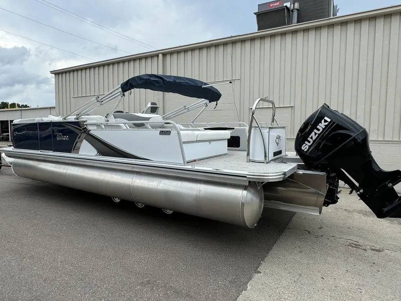 Slide: The Image of 2025 Tahoe LTZ 2385 VRB pontoon boat with Suzuki outboard motor, parked outdoors. - 2