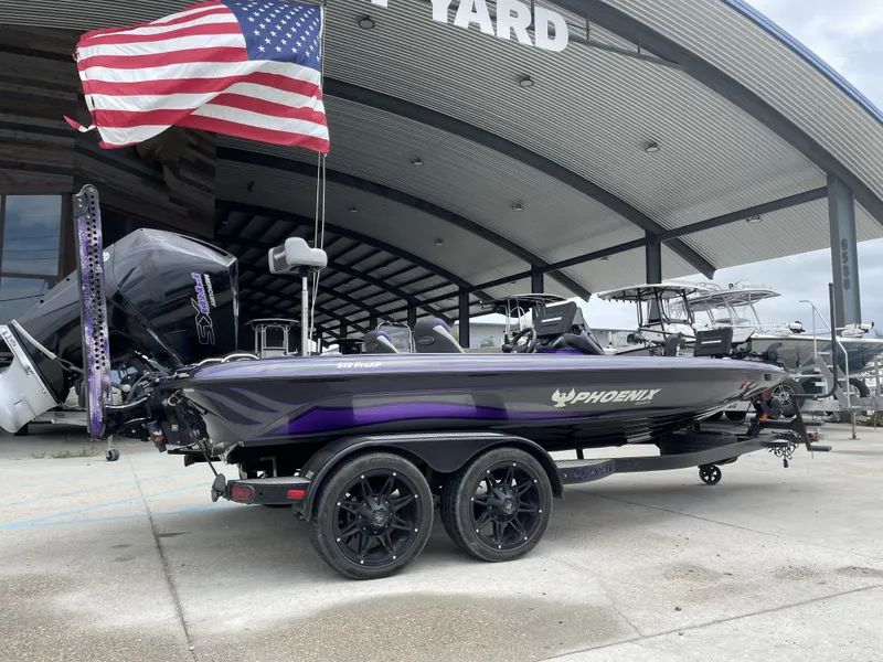 Slide: The Image of 2022 Phoenix 919 ProXP boat with American flag, parked at a marina. - 1