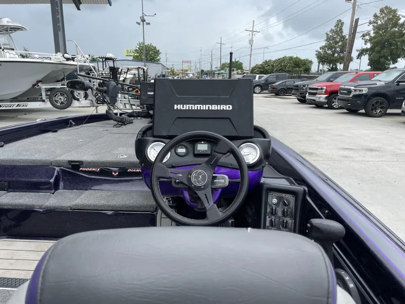 Slide: The Image of 2022 Phoenix 919 ProXP boat dashboard with Humminbird electronics in a parking lot. - 22