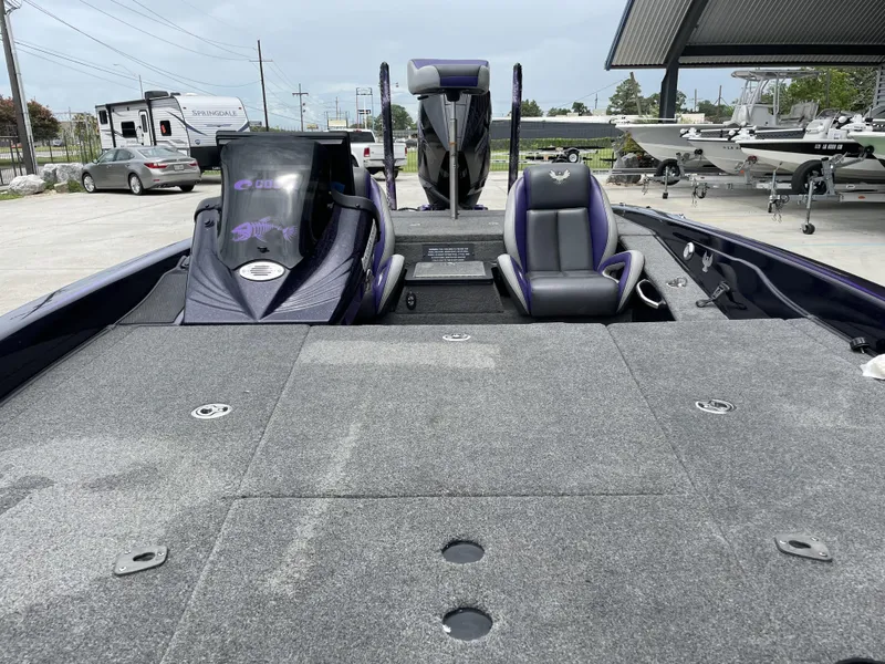 Slide: The Image of 2022 Phoenix 919 ProXP boat interior with seating and dashboard, parked outdoors. - 4