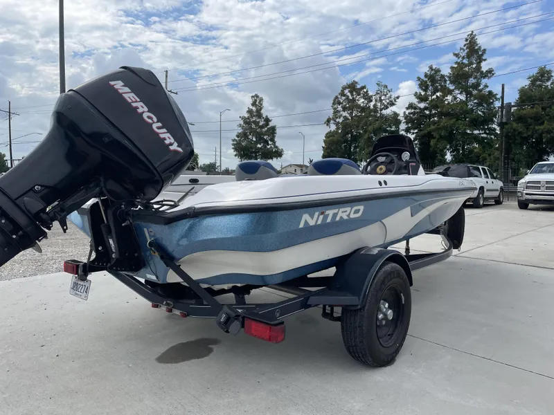 Slide: The Image of 2006 Nitro NX 750 boat with Mercury engine on trailer, parked outdoors. - 2