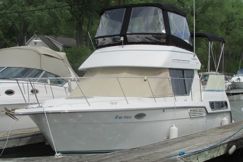 The Image of 1995 Carver 325 Aft Cabin boat docked at marina, featuring spacious upper deck. - 0