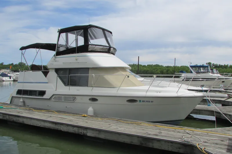 Slide: The Image of 1995 Carver 325 Aft Cabin yacht docked at marina under clear sky. - 1