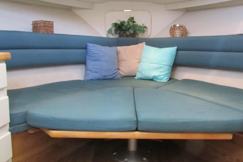 Slide: The Image of 1995 Carver 325 Aft Cabin interior with blue seating and colorful cushions. - 14