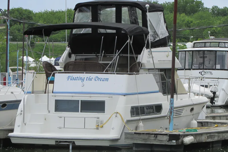 Slide: The Image of 1995 Carver 325 Aft Cabin yacht docked, named "Floating the Dream." - 2