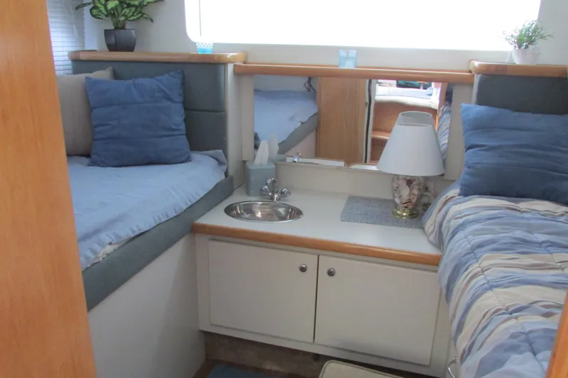 Slide: The Image of 1995 Carver 325 Aft Cabin interior with twin beds, sink, and cozy decor. - 22