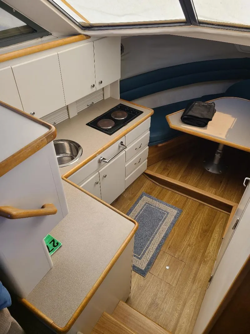 Slide: The Image of 1995 Carver 325 Aft Cabin interior with kitchen and dining area. - 34