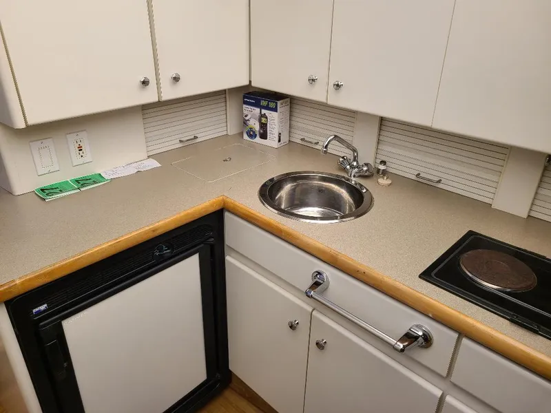 Slide: The Image of 1995 Carver 325 Aft Cabin kitchen with sink, stove, and compact fridge. - 39