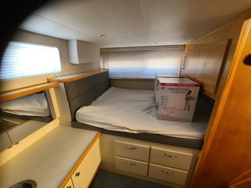Slide: The Image of 1995 Carver 325 Aft Cabin interior with bed, drawers, and window blinds. - 41