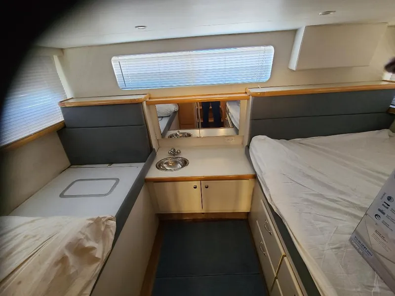 Slide: The Image of 1995 Carver 325 Aft Cabin interior with bed, sink, and storage cabinets. - 42