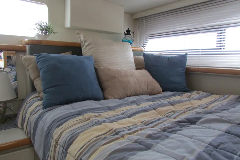 Slide: The Image of Cozy bedroom in 1995 Carver 325 Aft Cabin with striped bedding and decorative pillows. - 18