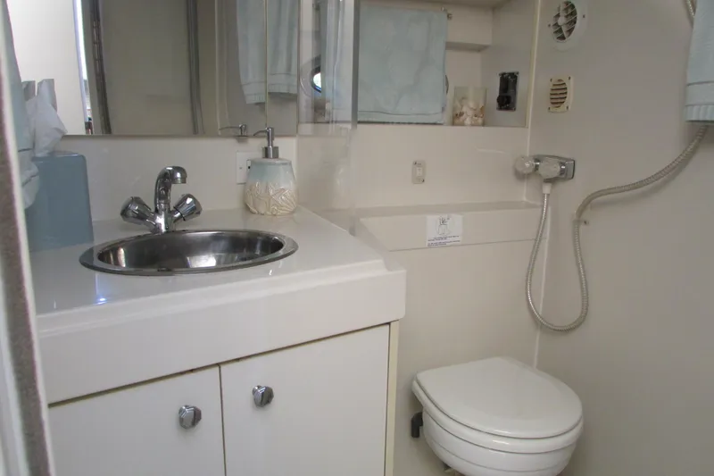Slide: The Image of 1995 Carver 325 Aft Cabin bathroom with sink, toilet, and showerhead. - 25