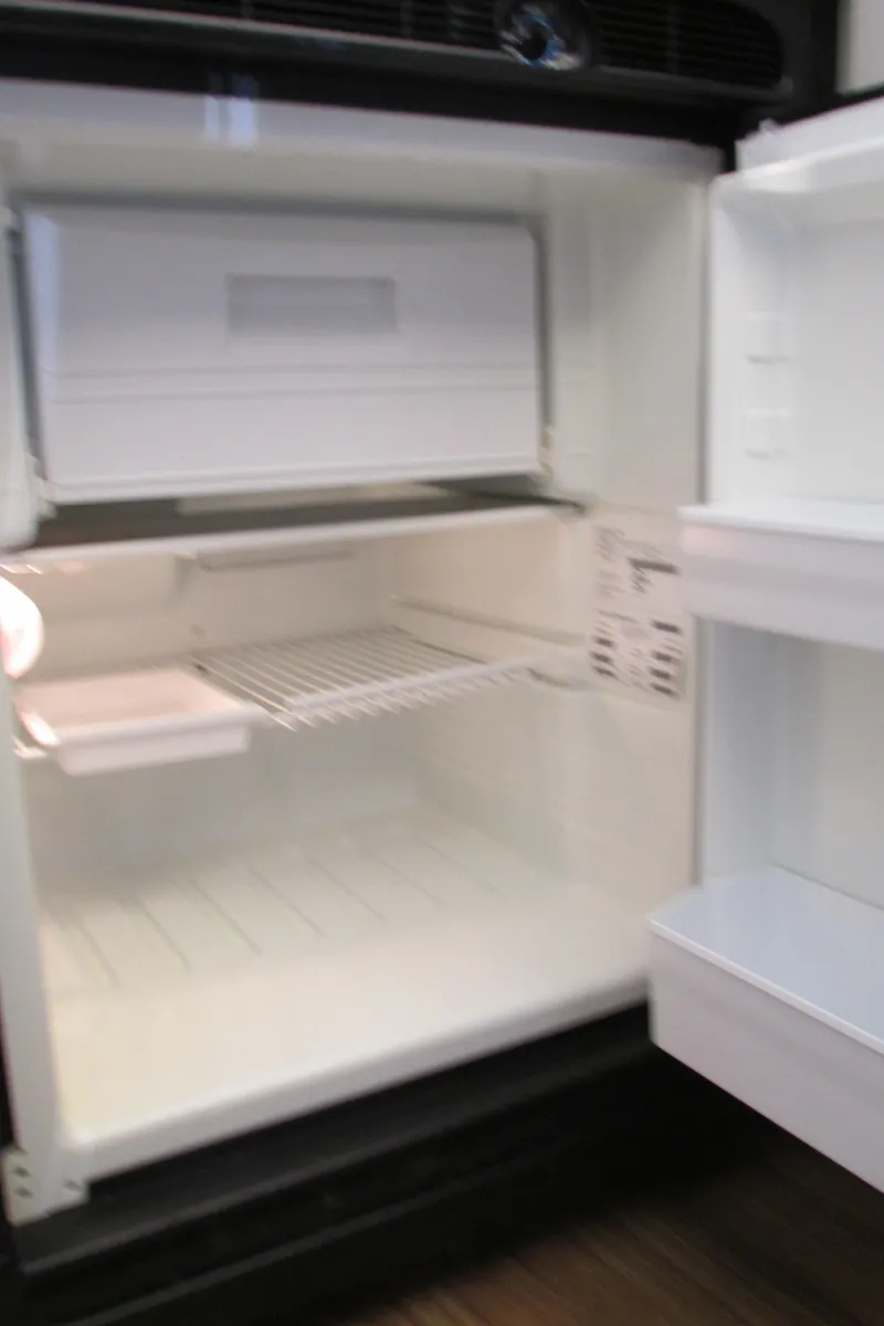 Slide: The Image of Open refrigerator inside 1995 Carver 325 Aft Cabin boat, showing empty shelves. - 26