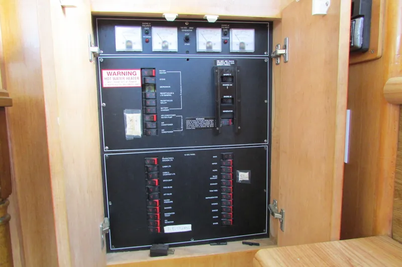 Slide: The Image of Electrical panel inside 1995 Carver 325 Aft Cabin boat, featuring circuit breakers and warning labels. - 27