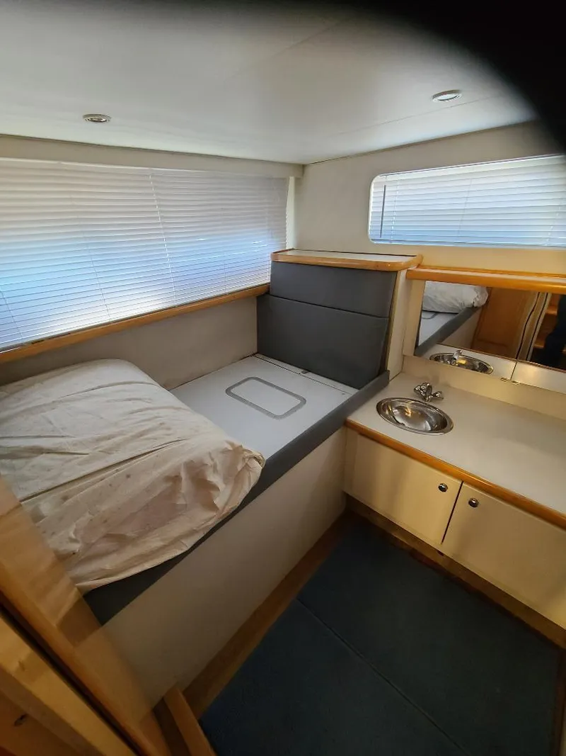 Slide: The Image of 1995 Carver 325 Aft Cabin interior with bed and sink, featuring modern design. - 43