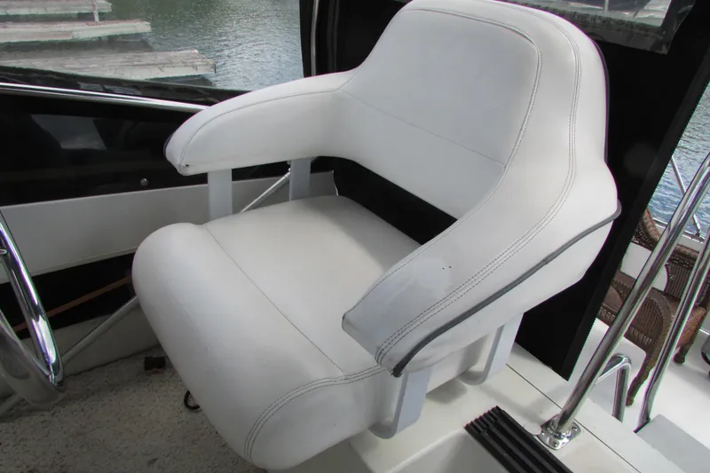 Slide: The Image of White captain's chair on 1995 Carver 325 Aft Cabin boat, near water. - 7