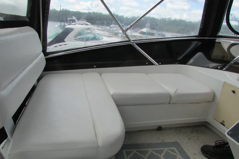 Slide: The Image of 1995 Carver 325 Aft Cabin interior with white seating, docked at marina. - 8