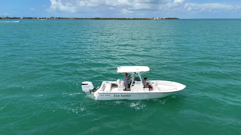 The Image of 2023 Sea Born LX24 boat cruising on turquoise ocean waters under a clear sky. - 1