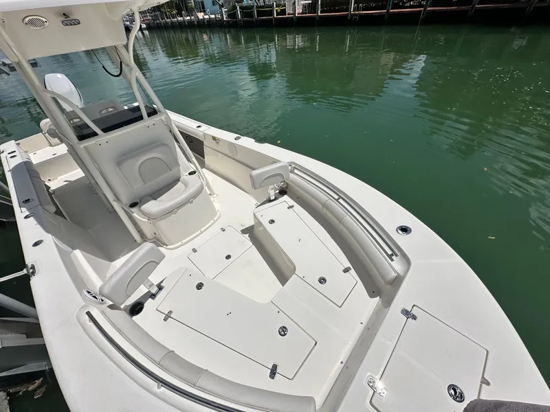 Slide: The Image of 2023 Sea Born LX24 boat on calm water, showcasing spacious deck and seating. - 11