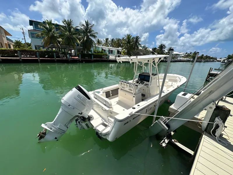 Slide: The Image of 2023 Sea Born LX24 boat docked in a tropical canal setting. - 18