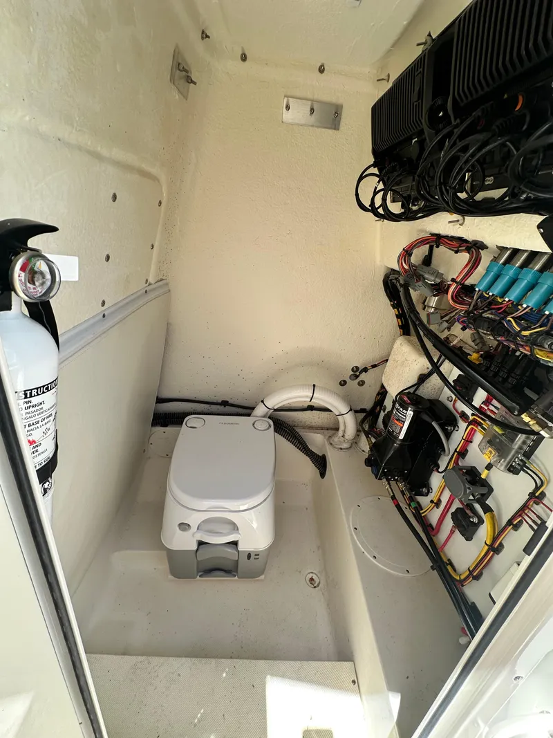Slide: The Image of 2023 Sea Born LX24 boat interior with portable toilet and electrical wiring. - 20