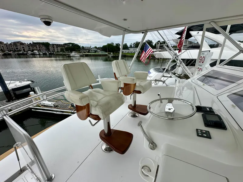 Slide: The Image of Viking 56 Convertible SONAR 2004 yacht helm with white captain chairs and marina view. - 9