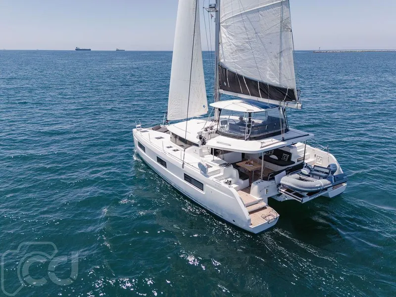 Slide: The Image of 2021 Lagoon 46 catamaran sailing on open sea, showcasing sleek design and spacious deck. - 10