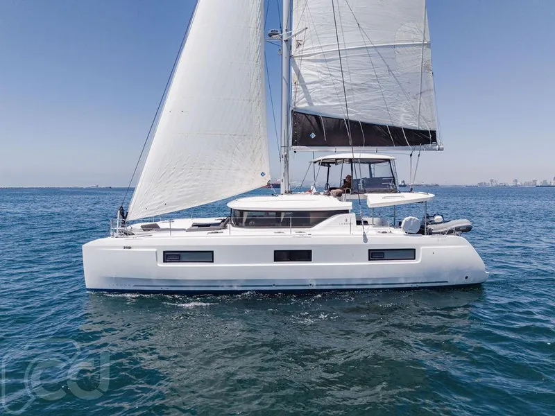 Slide: The Image of 2021 Lagoon 46 catamaran sailing on open water under clear blue skies. - 11