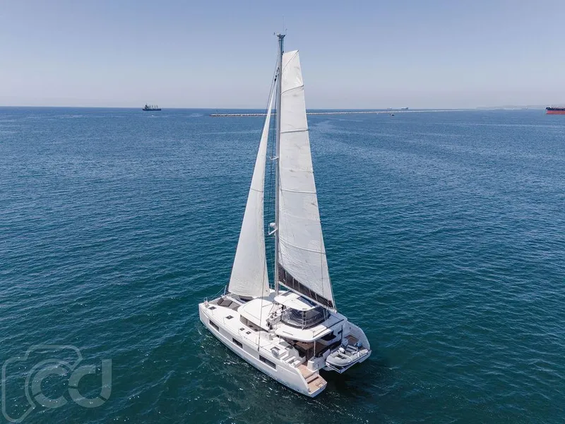 Slide: The Image of 2021 Lagoon 46 catamaran sailing on open sea under clear blue sky. - 14