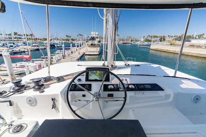 Slide: The Image of Helm of 2021 Lagoon 46 catamaran docked at marina, featuring navigation controls. - 17