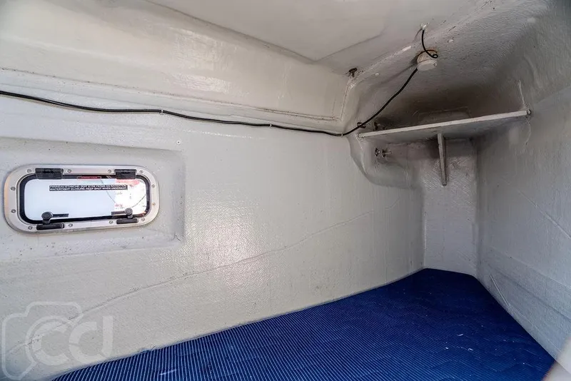 Slide: The Image of Interior cabin of 2021 Lagoon 46 catamaran with blue bedding and small window. - 18