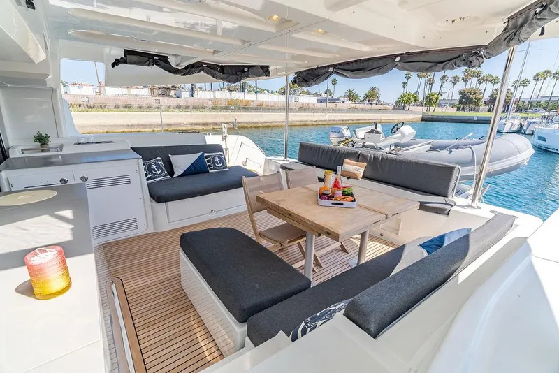 Slide: The Image of Luxurious Lagoon 46 yacht interior, 2021 model, featuring elegant seating and dining area by the water. - 21