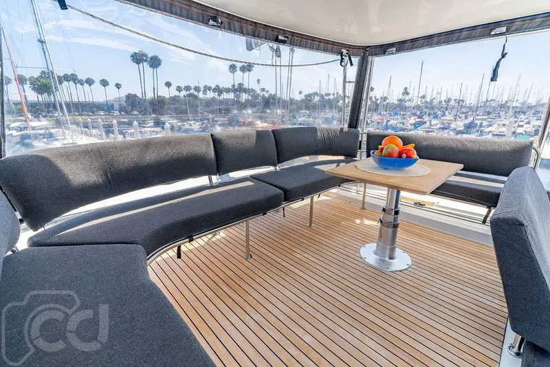 Slide: The Image of Spacious Lagoon 46 yacht interior with modern seating and table, overlooking marina. - 30