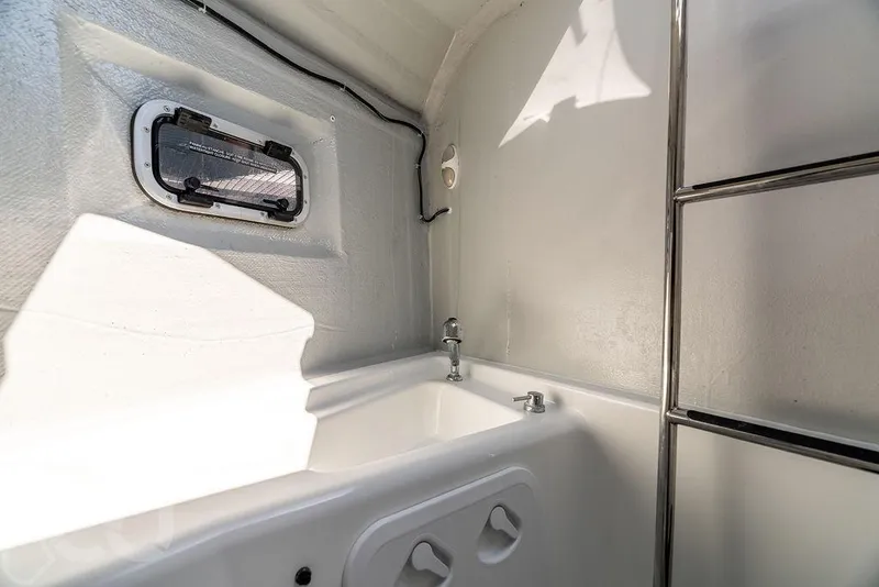 Slide: The Image of Interior of 2021 Lagoon 46 yacht bathroom with window and fixtures. - 33