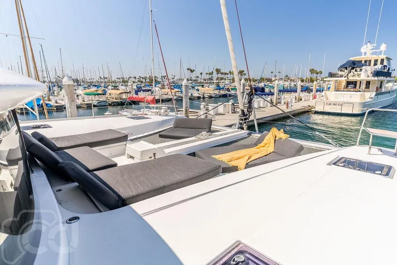 Slide: The Image of 2021 Lagoon 46 catamaran docked in a sunny marina with luxurious seating. - 39