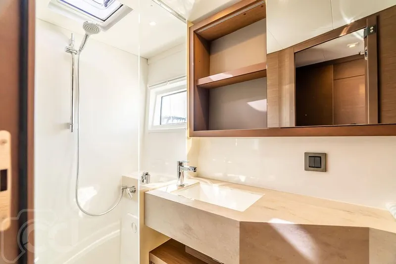 Slide: The Image of Modern bathroom in 2021 Lagoon 46 yacht with shower, sink, and wooden cabinetry. - 45