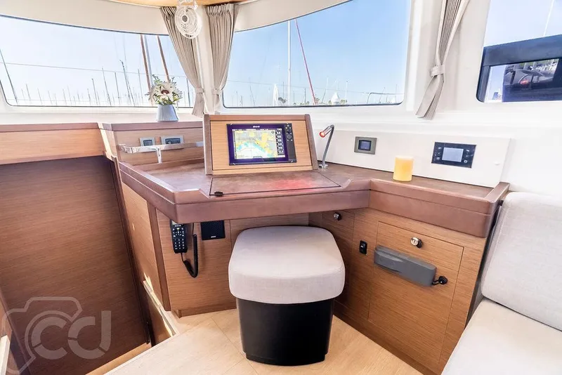 Slide: The Image of Modern navigation station inside 2021 Lagoon 46 catamaran with electronic display and comfortable seating. - 48