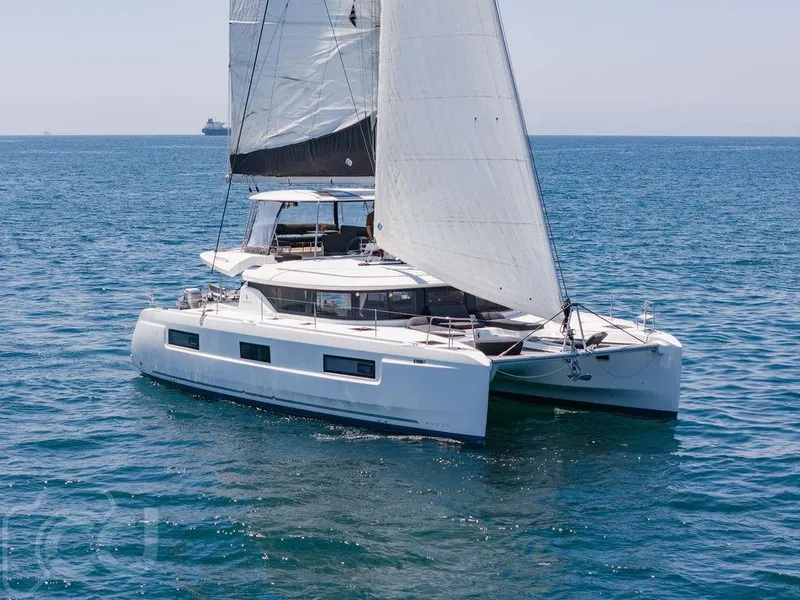 Slide: The Image of 2021 Lagoon 46 catamaran sailing on open sea with full sails. - 5