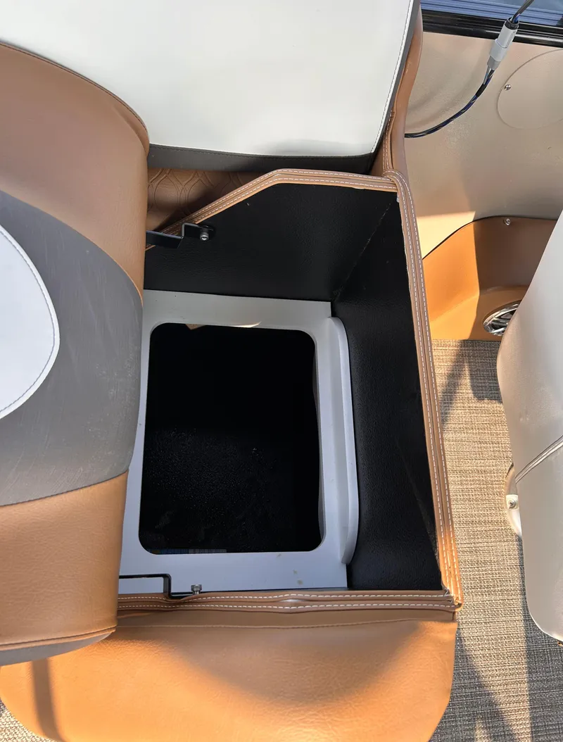 Slide: The Image of 2024 Avalon Catalina Quad Lounge storage compartment, brown and white seating, open view. - 14