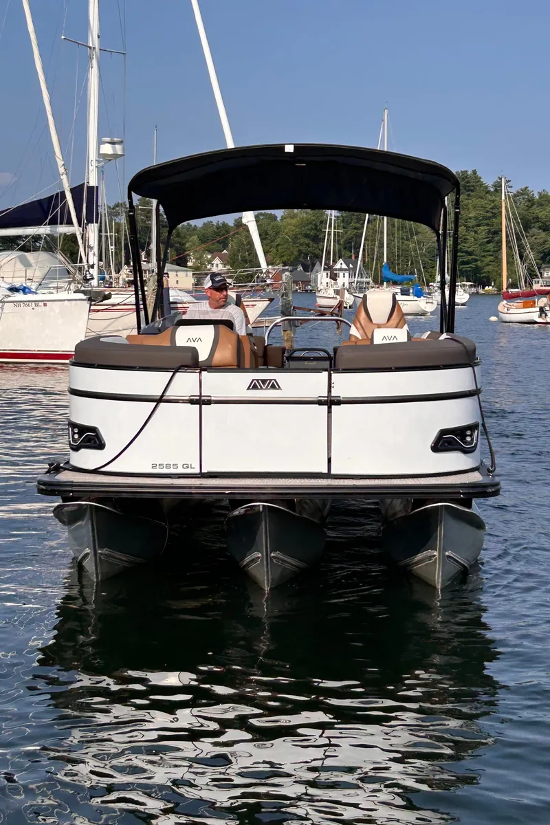 Slide: The Image of 2024 Avalon Catalina Quad Lounge 25' pontoon boat on water, surrounded by other boats. - 2