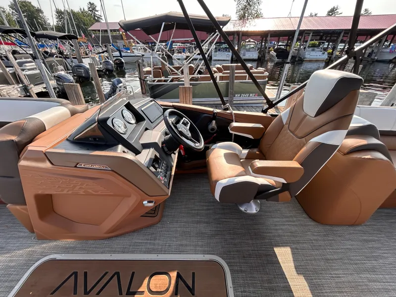 Slide: The Image of 2024 Avalon Catalina Quad Lounge boat interior with captain's chair and control panel. - 22
