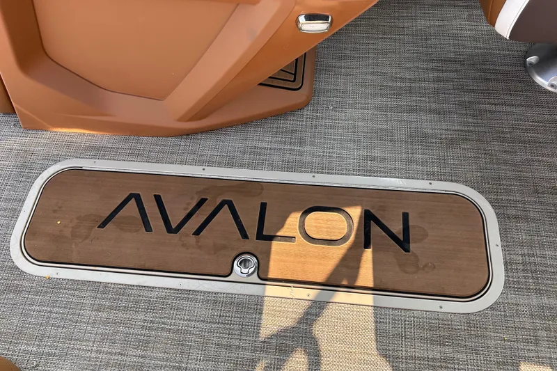 Slide: The Image of Avalon Catalina Quad Lounge 2024 boat interior with logo on wooden panel. - 25