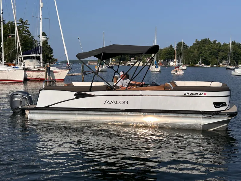 Slide: The Image of 2024 Avalon Catalina Quad Lounge 25' pontoon boat on a serene lake. - 3