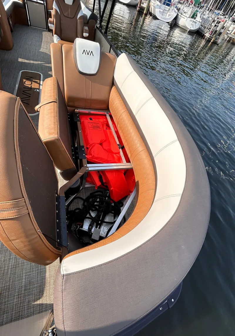 Slide: The Image of 2024 Avalon Catalina Quad Lounge boat with open storage compartment by the dock. - 32