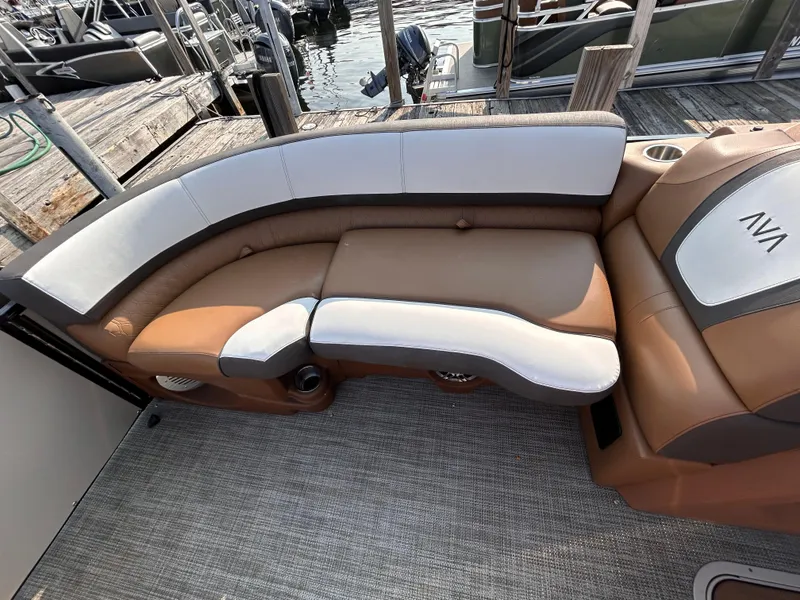 Slide: The Image of 2024 Avalon Catalina Quad Lounge boat interior with tan and white seating, dockside view. - 33