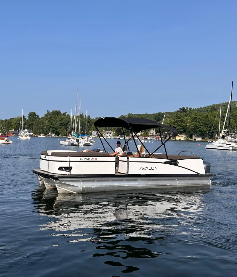 Slide: The Image of 2024 Avalon Catalina Quad Lounge 25' pontoon boat on a scenic lake. - 4