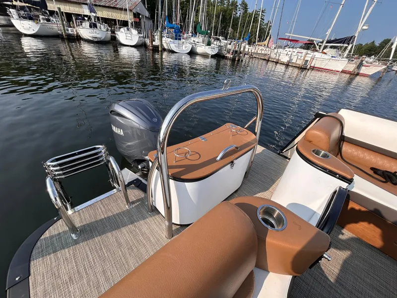 Slide: The Image of 2024 Avalon Catalina Quad Lounge 25' boat at marina, featuring luxurious seating and Yamaha motor. - 9