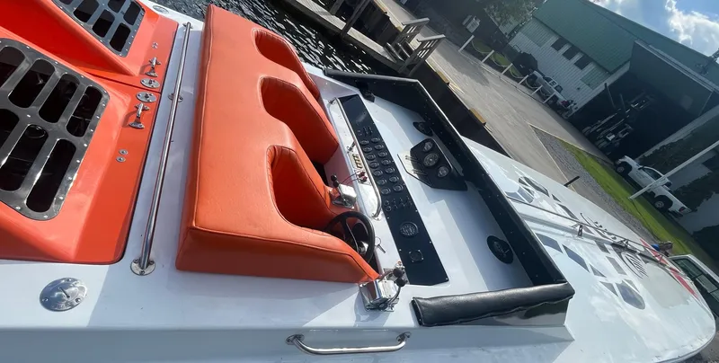 Slide: The Image of 1979 Scarab Larry Smith 38 boat dashboard with orange seating and control panel. - 11