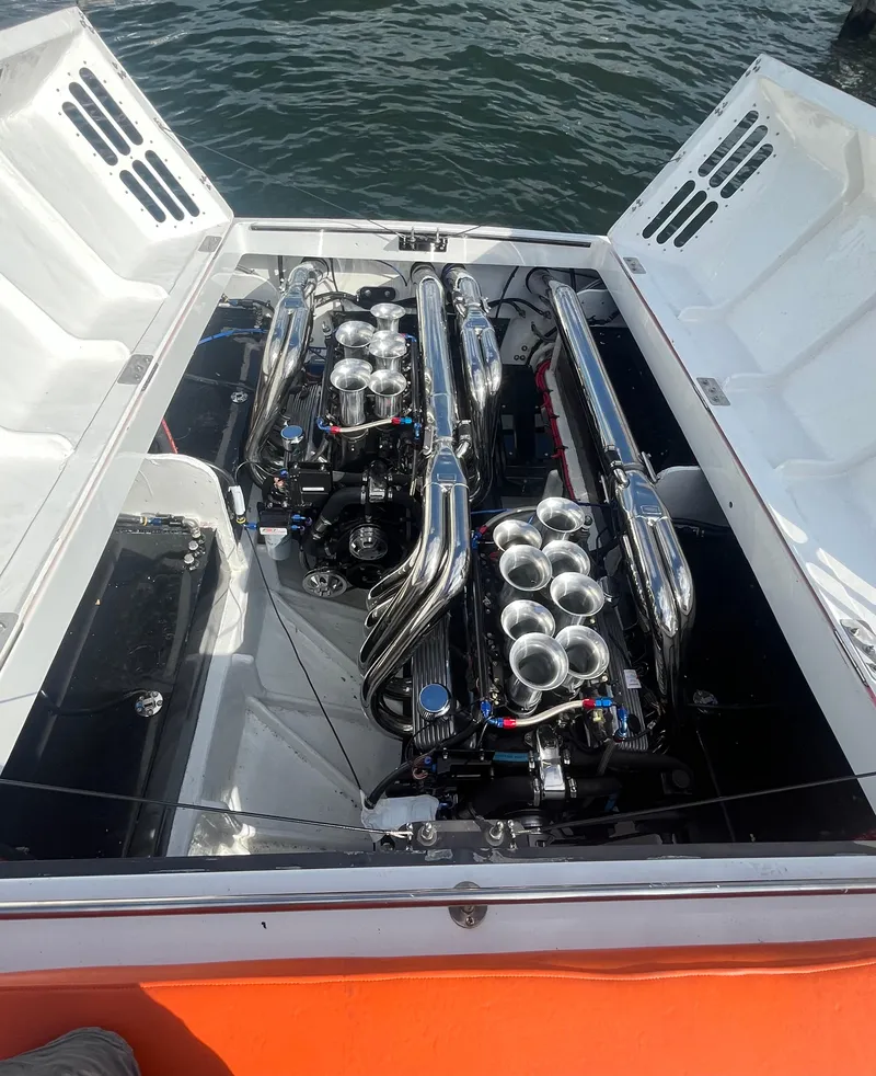 Slide: The Image of 1979 Scarab Larry Smith 38 boat with dual engines, open engine compartment, docked on water. - 13