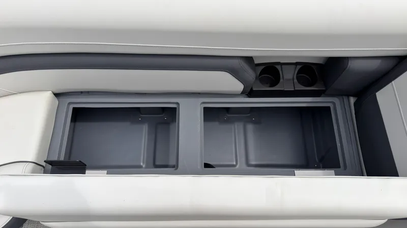 Slide: The Image of Storage compartment in the seating area of the 2025 Starcraft EXS 3 FD TT with cup holders. - 21